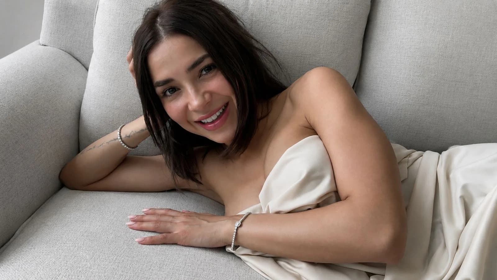 La fundadora de Simonetta sonriendo en un sofá gris con pulseras de plata