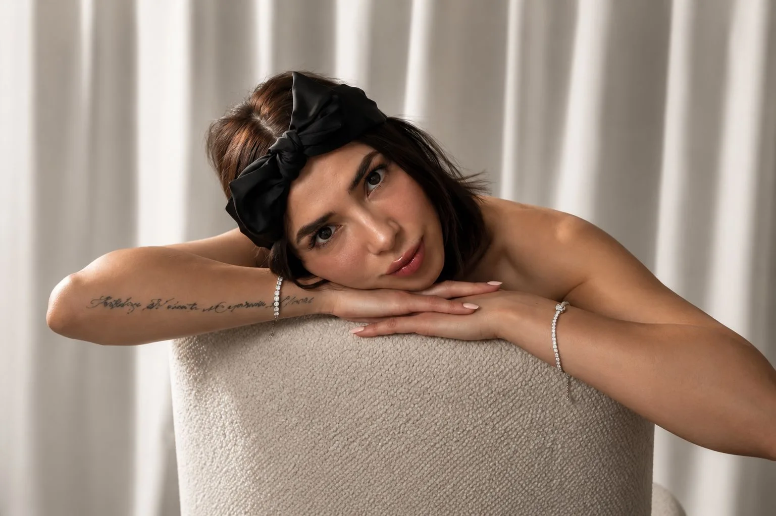 La fundadora de Simonetta apoyada en una silla boucle con pulseras de plata
